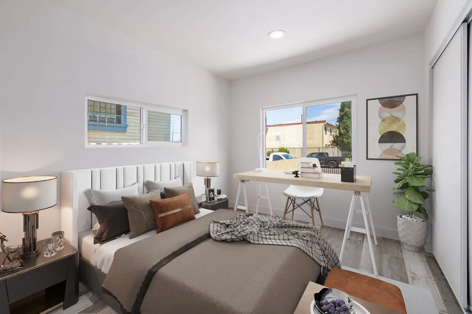 Bright bedroom with an upholstered bed, writing desk and two windows