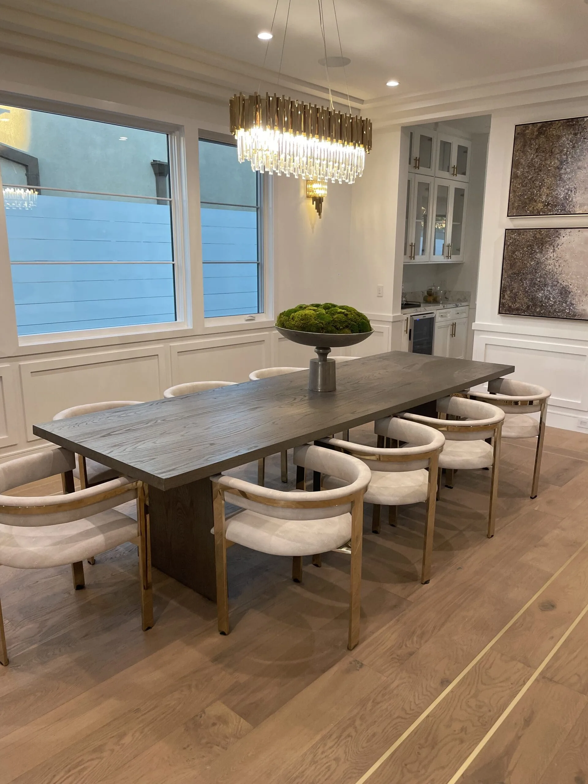 Dining room with a crystal chandelier, long dining table and wood floors