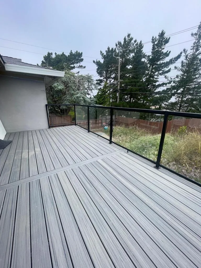 Long grey composite deck with a glass railing running along the house at 477 Nevada St, San Francisco