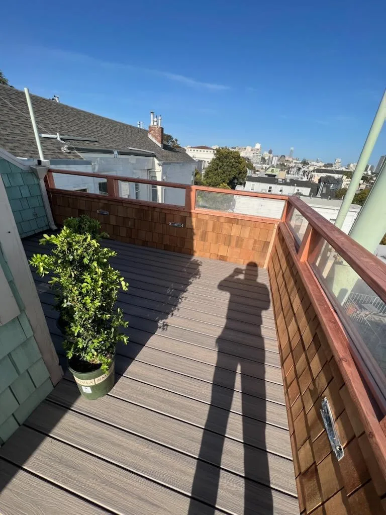 Rooftop deck with composite decking and cedar shingle and glass parapets overlooking the city on Brodrick Street, San Francisco