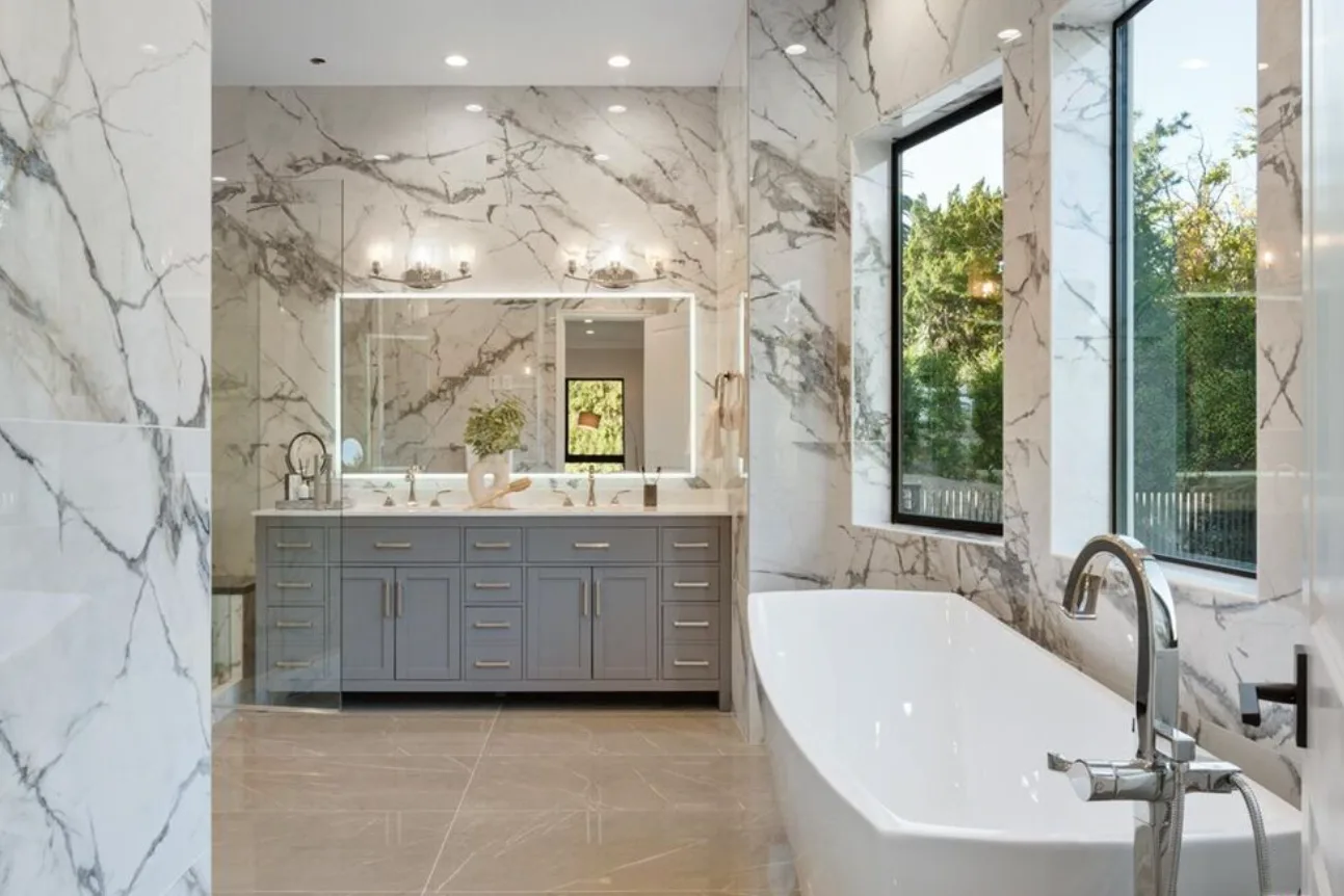 Bathroom remodel with marble-look porcelain walls, a grey double vanity, a backlit mirror and a freestanding tub on E Sierra Madre Blvd, Sierra Madre
