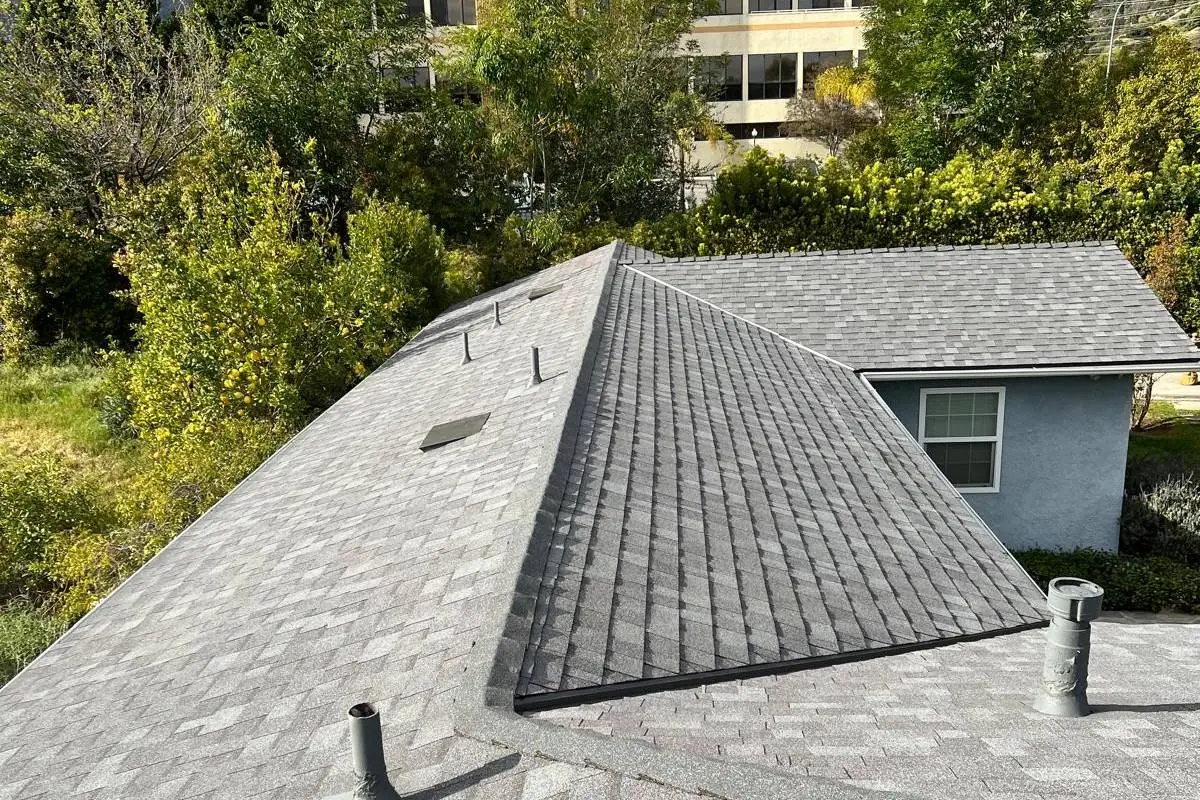 New grey asphalt shingle roof on a single-storey home framed by trees on Woodlyn Rd, Pasadena