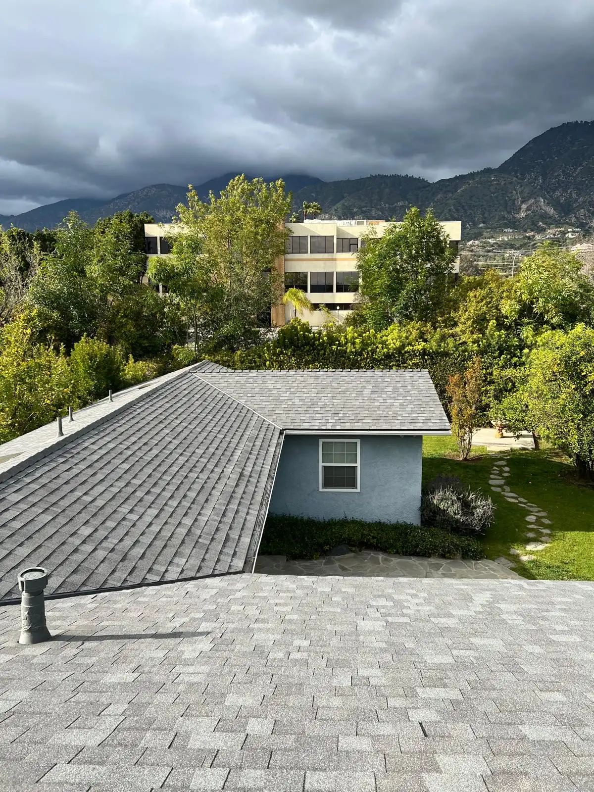 Rooftop view of the new grey shingles with the mountains beyond on Woodlyn Rd, Pasadena