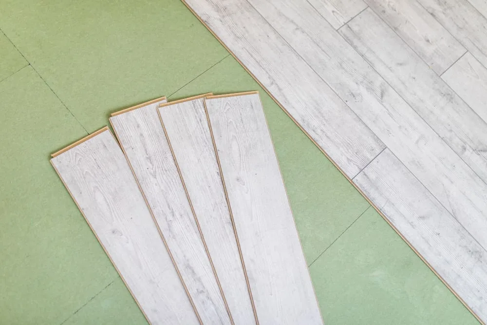 Whitewashed laminate planks on green foam underlay