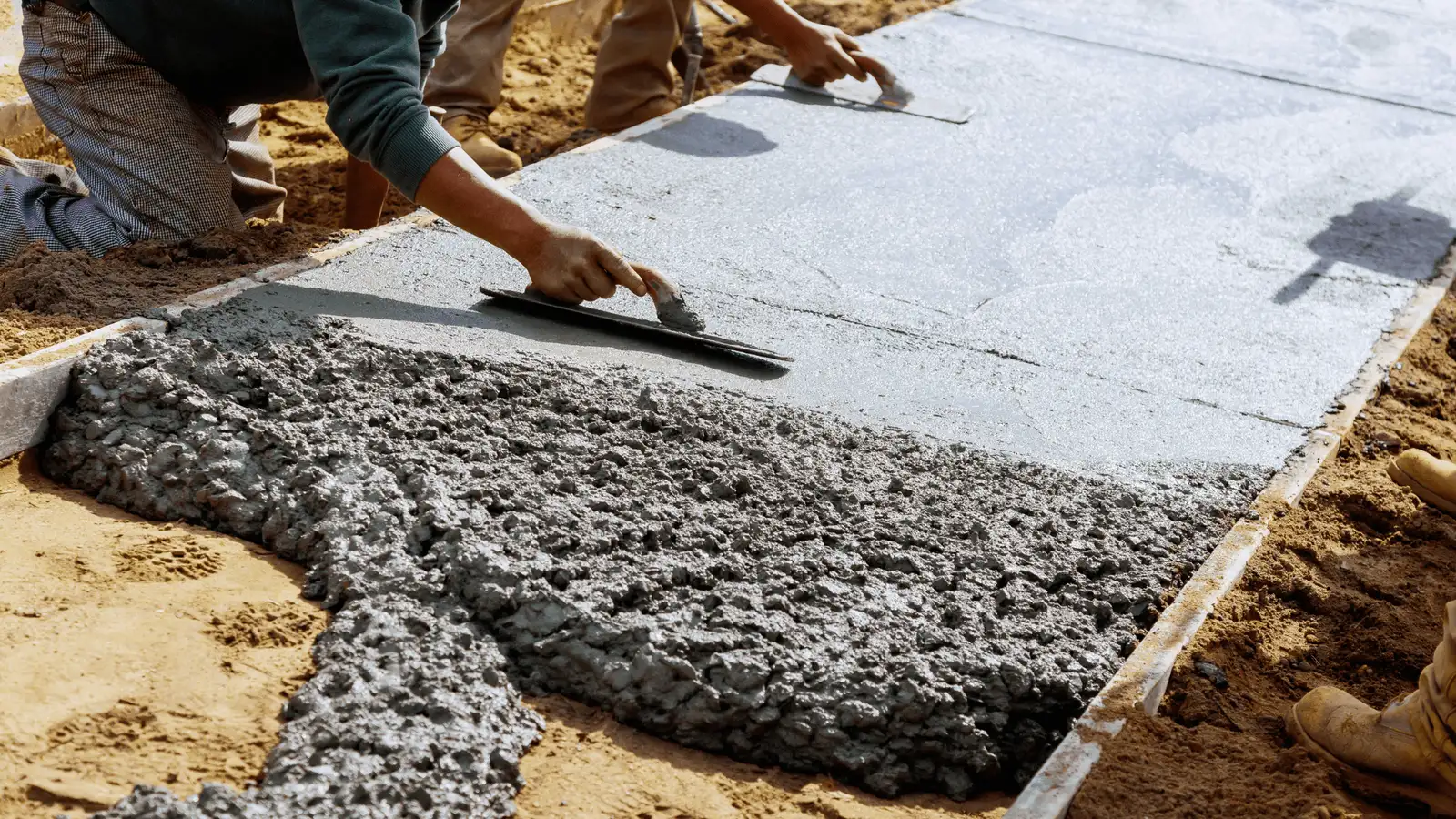 Concrete contractors troweling a freshly poured slab